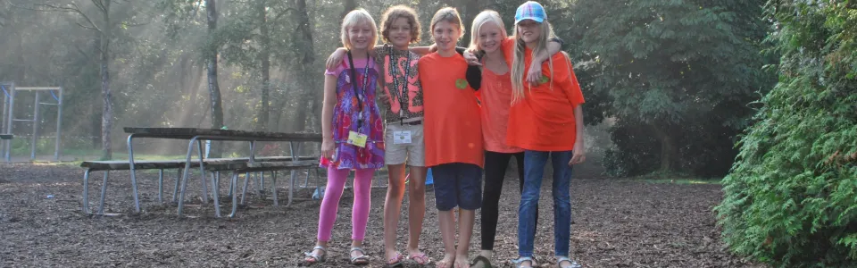 Kinderen in het bos met zonlicht tussen de bomen