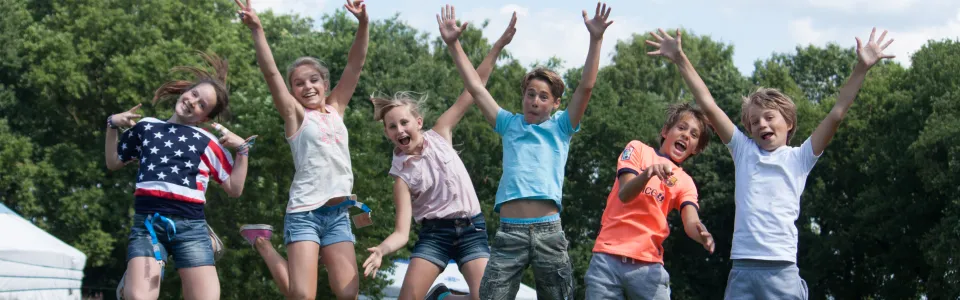 Deelnemers springen samen in de lucht op het grasveld