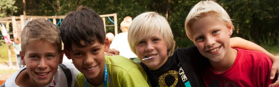 Vier jongens met de armen om elkaar heen