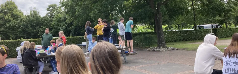 Deelnemers zitten op banken te kijken naar een optreden