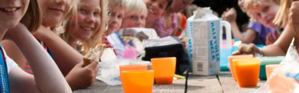 Kinderen aan een tafel met gekleurde bekers