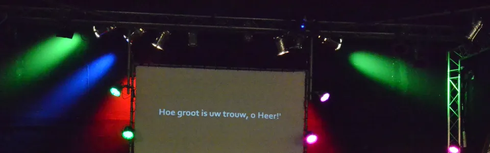 Groepsfoto van de trainingsdag voor een verlicht podium