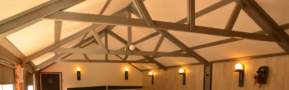 Zaal met houten balken en tafels