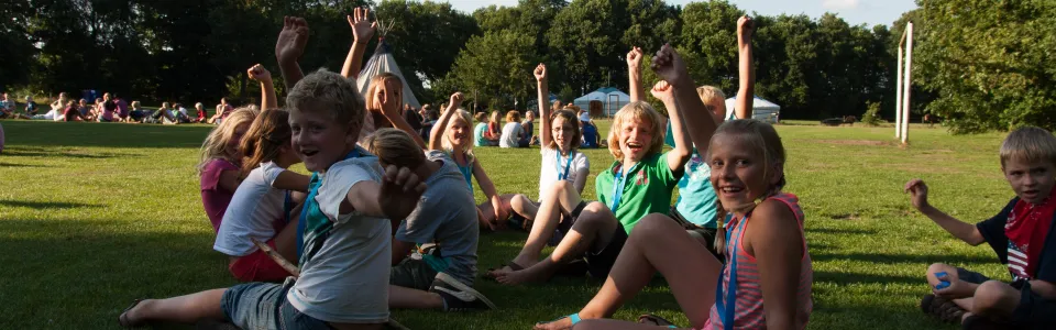 Deelnemers zitten in een grote kring op de zandvlakte