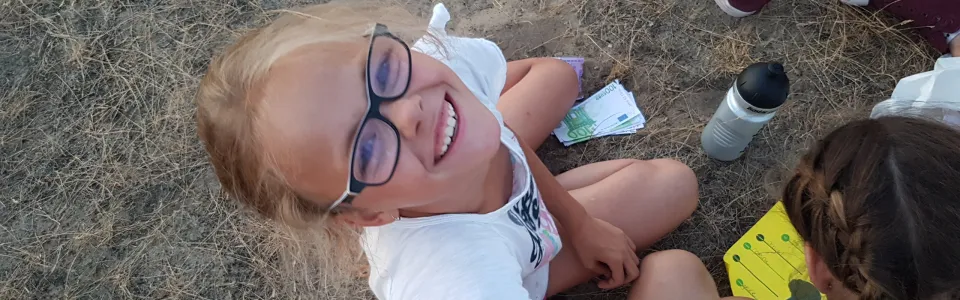 Deelnemer ligt op de grond met een opdrachtkaart