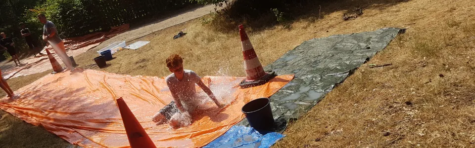 Deelnemer glijdt over een nat zeil