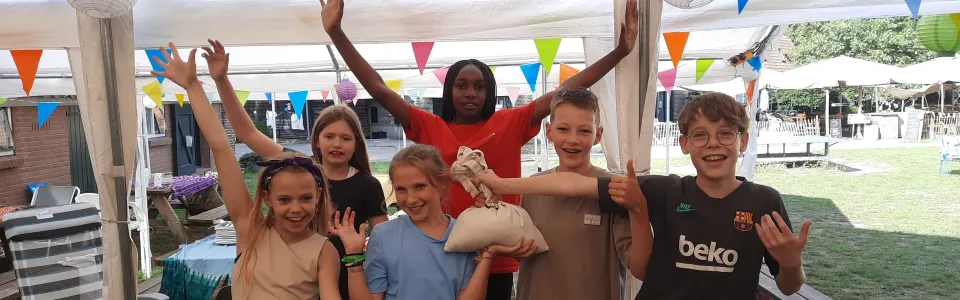 Deelnemers met de handen in de lucht onder een partytent