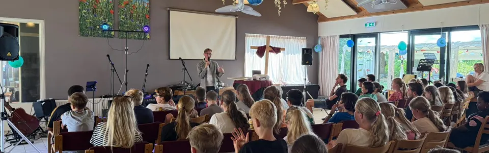 Volle zaal met deelnemers onder papieren slingers