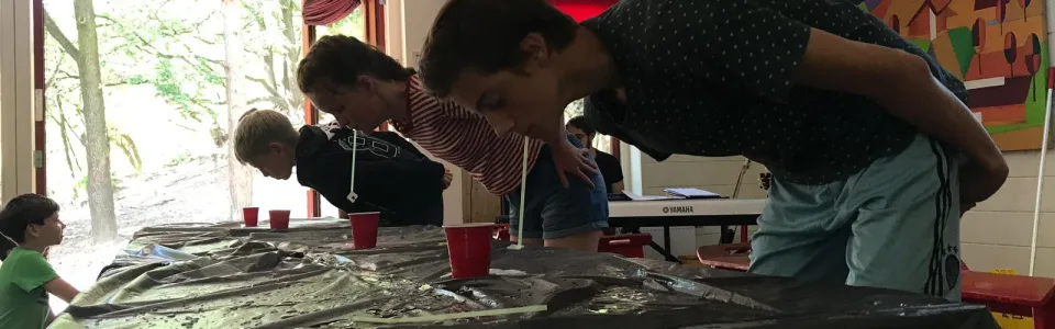 Deelnemer duikt over een natte tafel