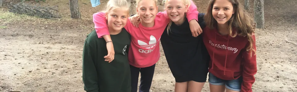 Vier meisjes poseren in het zand