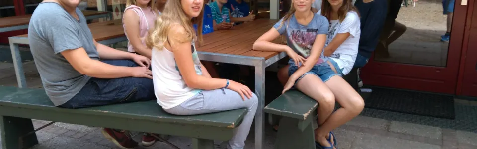 Deelnemers aan een picknicktafel op het terras