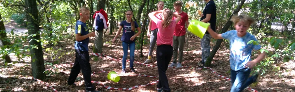 Deelnemers spelen een spel tussen de bomen
