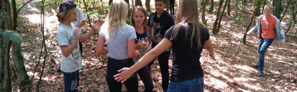 Deelnemers staan in een kring in het bos