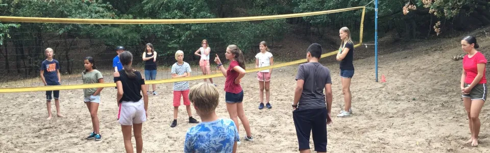 Deelnemers bij het volleybalnet op het zandveld