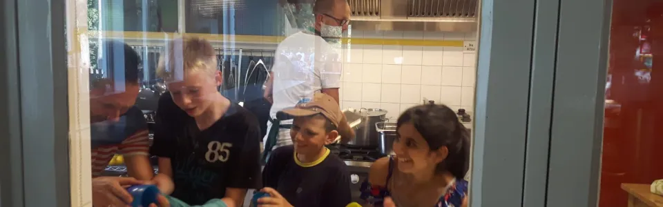 Deelnemers bij het doorgeefluik van de keuken