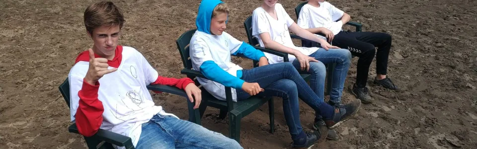 Deelnemers spelen touwtrekken in het zand