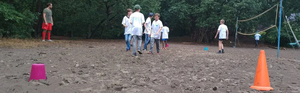 Deelnemers spelen een spel op het zandveld