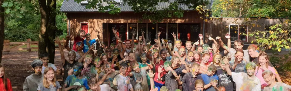 Grote groep deelnemers juicht bij het kampgebouw
