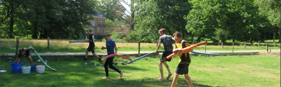 Deelnemers spelen een spel met linten op het grasveld