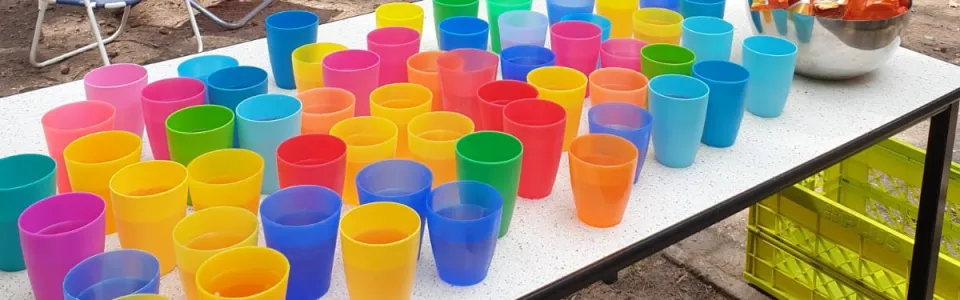 Gekleurde bekers op een tafel onder de vlaggetjes