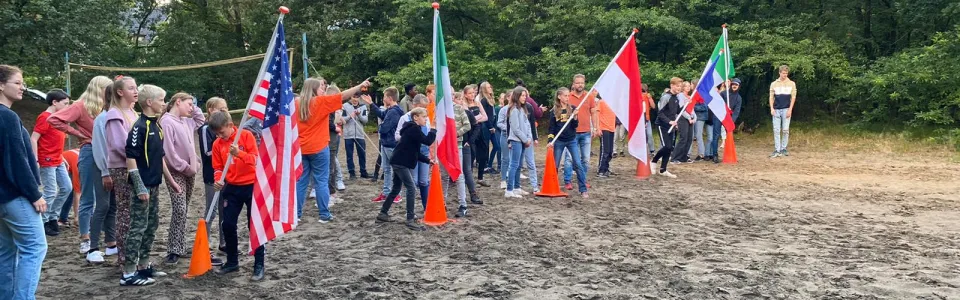 Deelnemers met vlaggen van verschillende landen op het zandveld