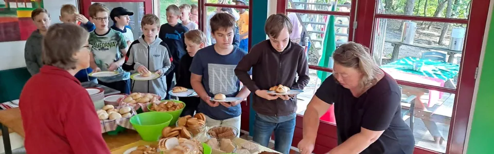 Deelnemers halen eten bij het buffet in de eetzaal