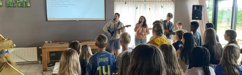Deelnemers staan in de zaal tijdens het programma