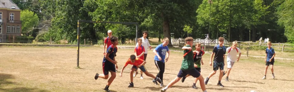Deelnemers spelen voetbal op het grasveld