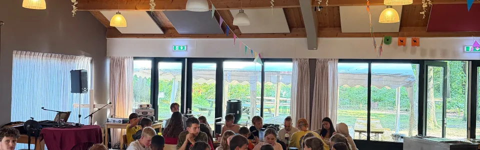 Deelnemers aan tafel in een versierde zaal