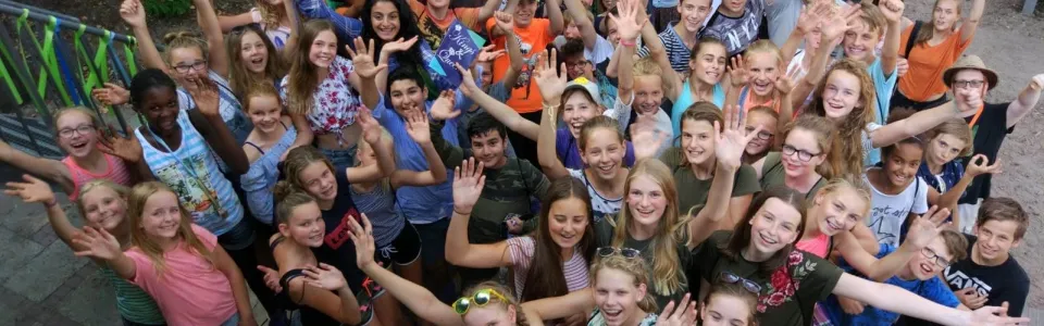 Grote groep deelnemers van brugkamp juicht naar de camera