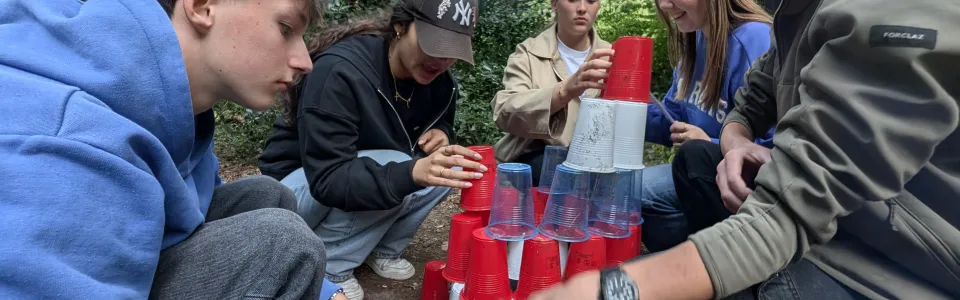 Deelnemers bouwen een toren van bekers