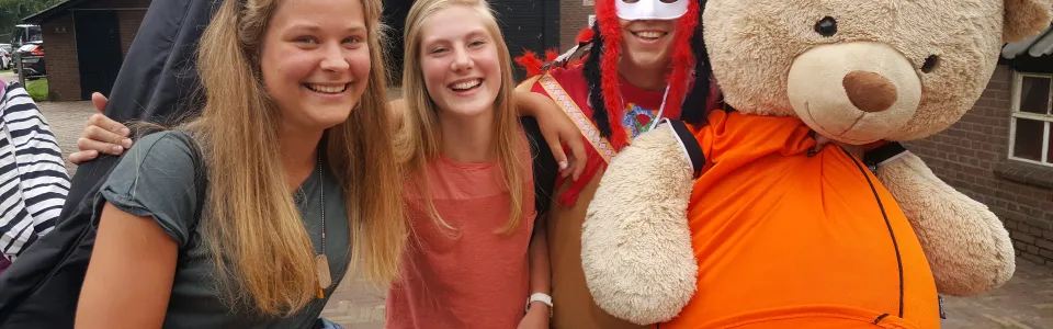 Deelnemers met een indianentooi en een grote knuffelbeer