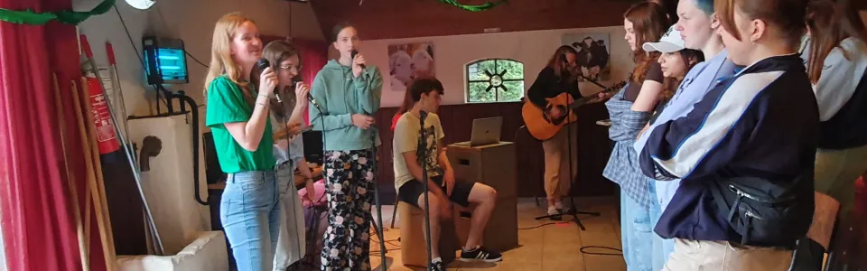 Zangteam zingt met microfoons in de zaal