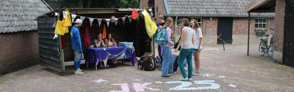 Deelnemers op het plein bij het kampgebouw met krijttekening