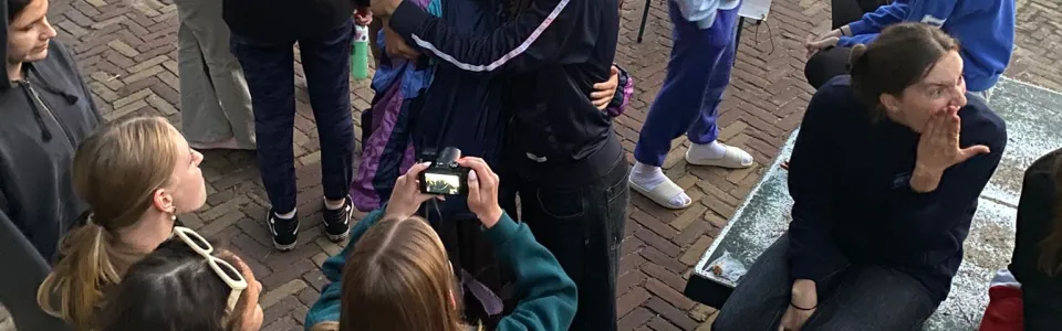 Deelnemers staan bij elkaar op het plein