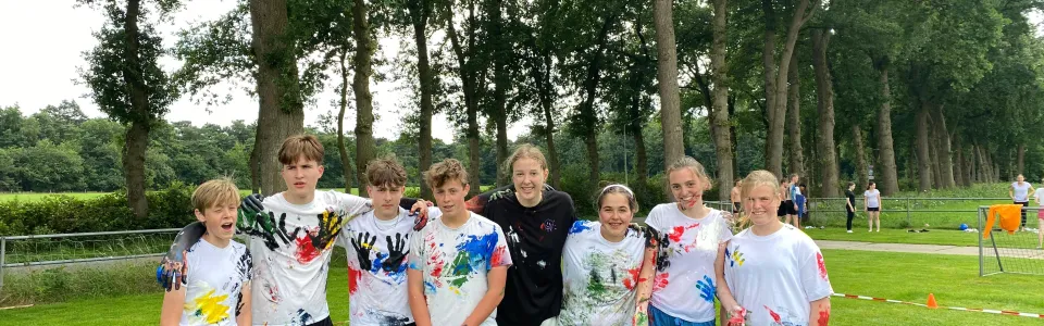 Deelnemers met beschilderde shirts poseren op het grasveld