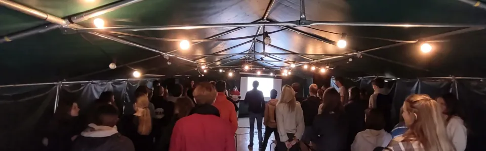Deelnemers lopen door de partytent tijdens het programma