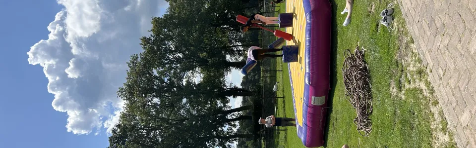 Deelnemer ligt op een opblaasbaar kussen in het gras