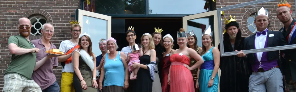 Groep in feestelijke kleding voor het kampgebouw