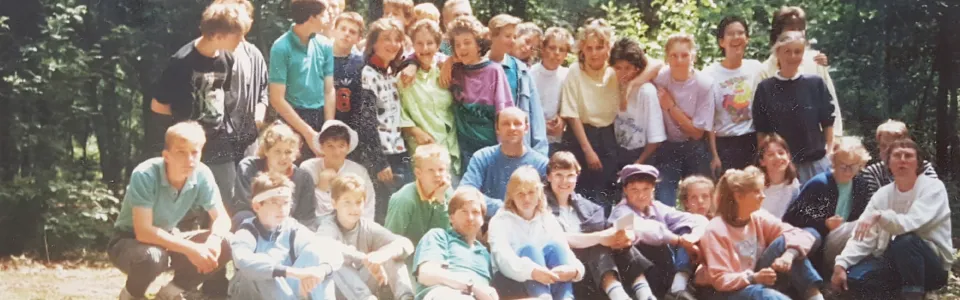 Grote groepsfoto van het jeugdkamp in het bos, 1989