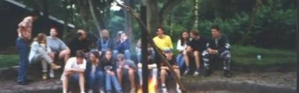 Deelnemers rond een kampvuur in het bos bij Lieren
