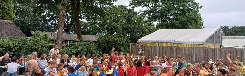 Deelnemers aan lange tafels onder de overkapping