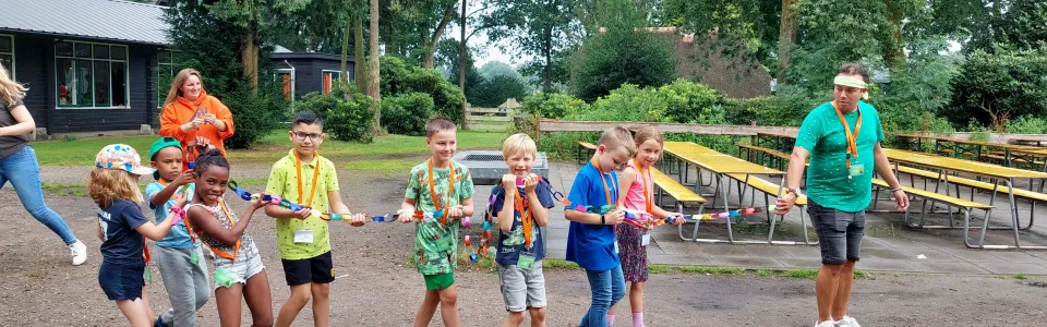 Met alle zorg worden de net gemaakte vlaggetjes vervoerd naar de ochtendprogrammazaal!