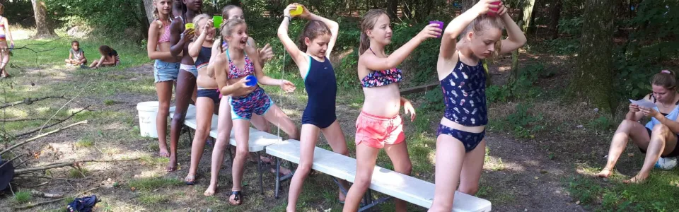 Deelnemers spelen een waterspel op het terrein