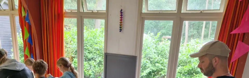 Kinderen knutselen aan tafel in de zaal