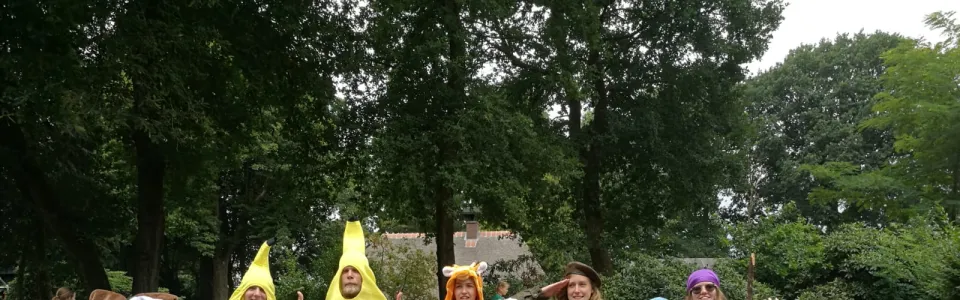 Deelnemers zitten op het gras bij een spel