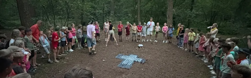 Deelnemers staan in een kring op het zandveld