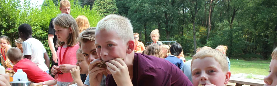 Deelnemers eten boterhammen aan tafel