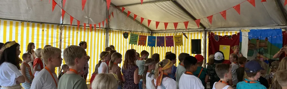 Deelnemers in de tent met gele en witte banen