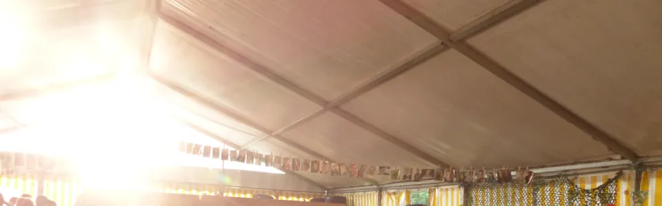 Deelnemers in een tent met tegenlicht van de zon